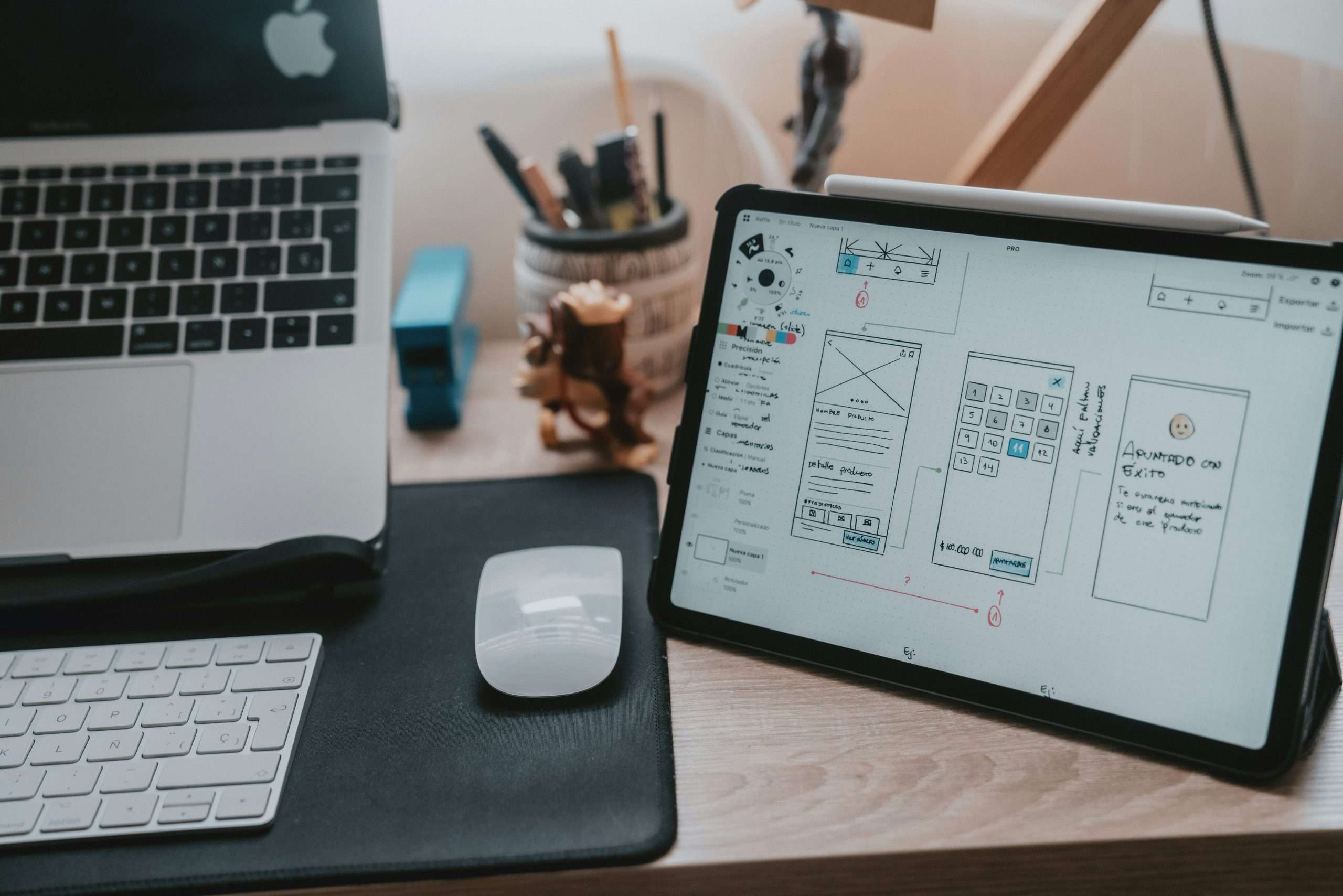 Website wireframe sitting on a desk next to a macbook laptop