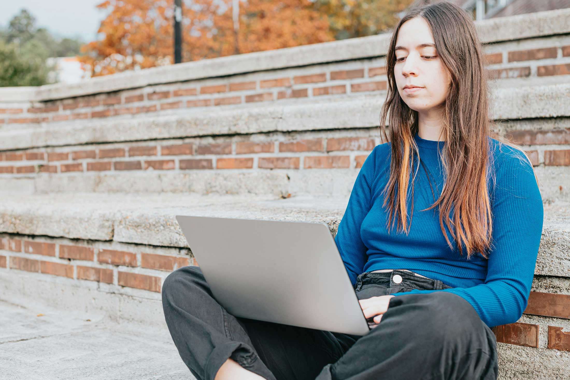 A woman writing on her laptop creating website copywriting