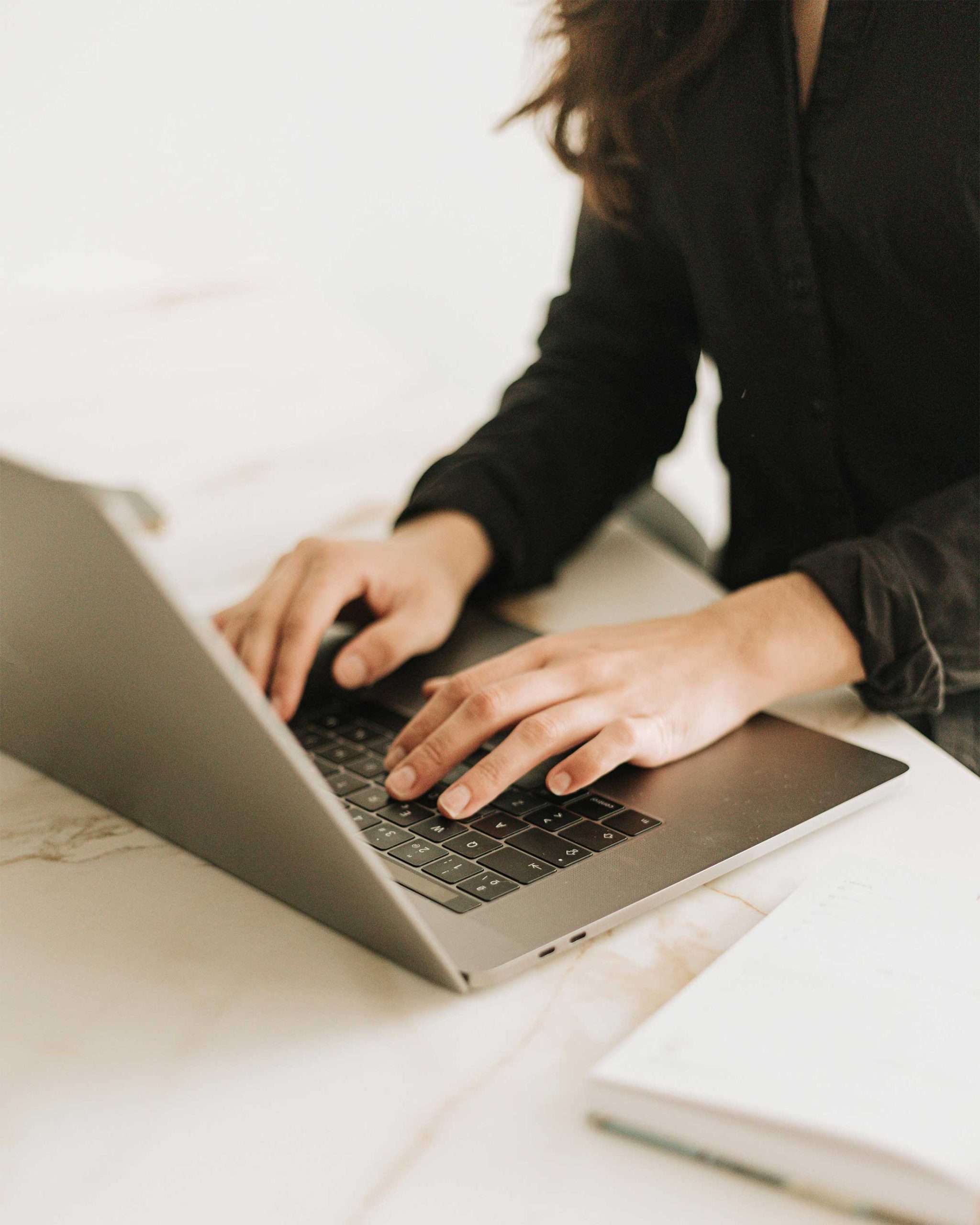 pexels-lorena-villarreal-546639145-30612694 Hands typing on laptop beside notebook and coffee cup — custom website design for entrepreneurs and small business owners.