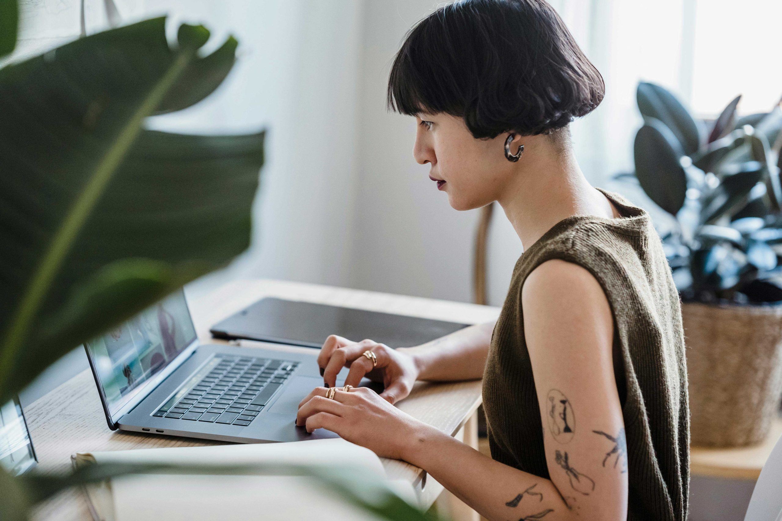 Designer working on a laptop in a minimalist workspace, illustrating the hands-on creative process of building a custom website compared to using an AI website builder.