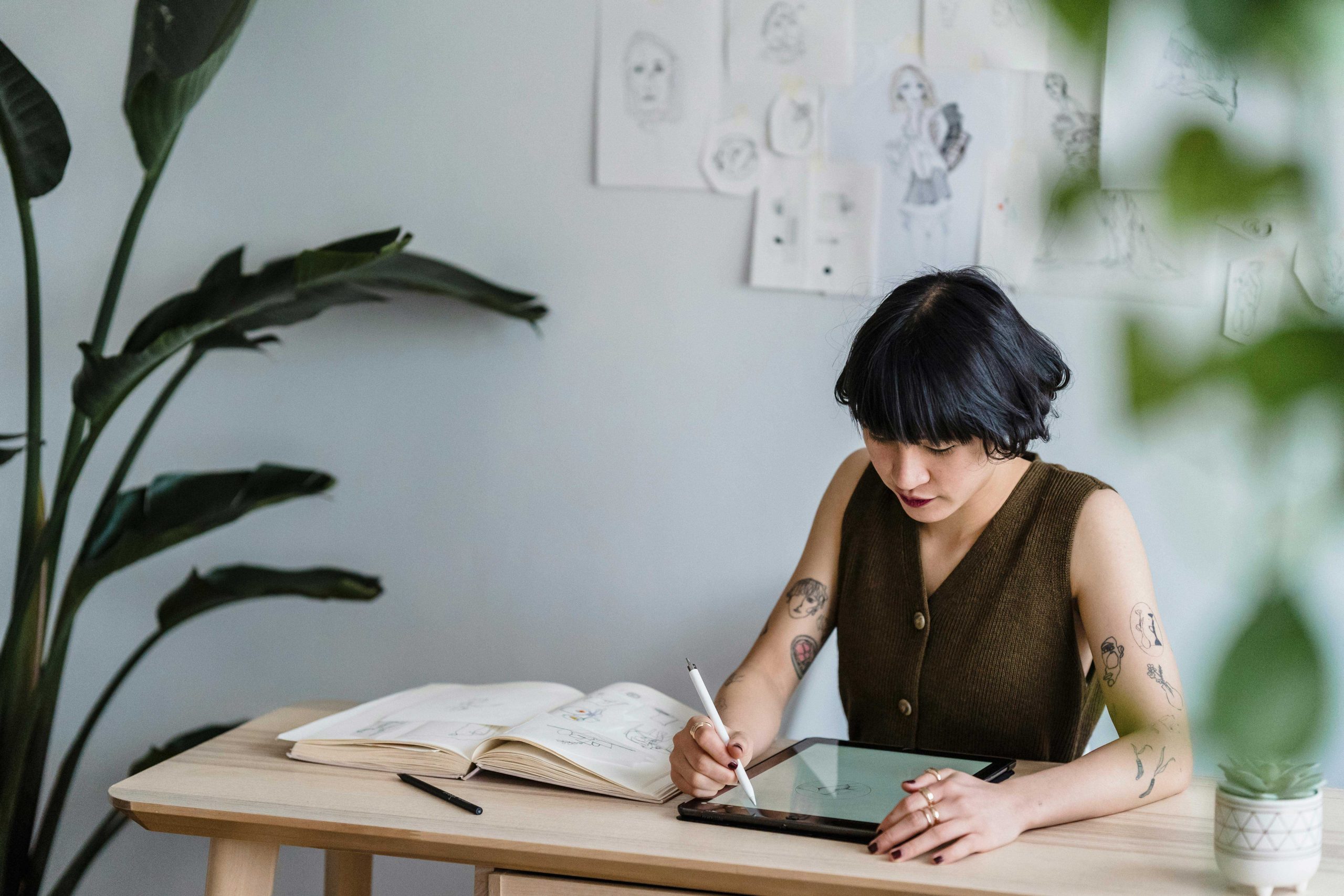 Artist sketching on a digital tablet in a minimalist workspace, representing the creative process of web design versus AI website builders.