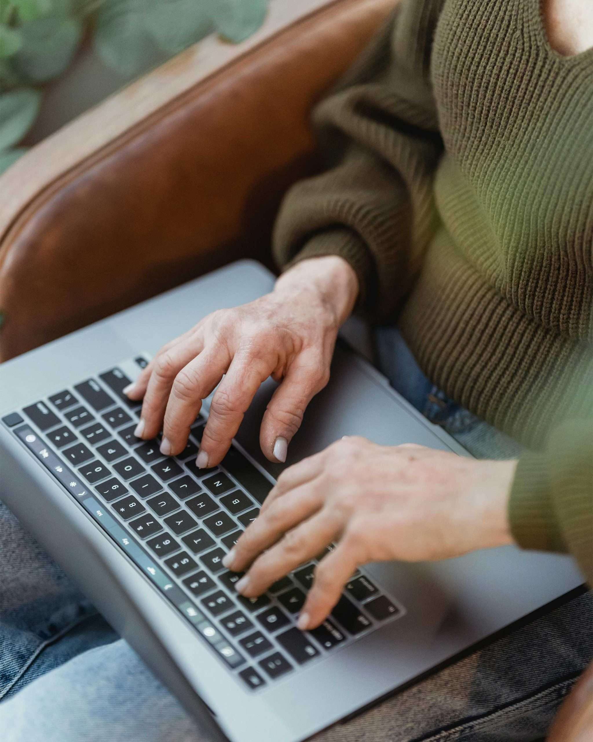 Website Strategy Session | Westco Web Design Hands typing on laptop while sitting on leather chair — WordPress website strategy and support services.
