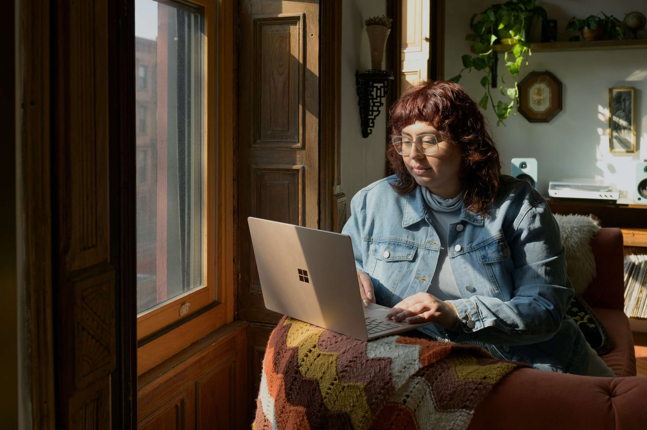 4 SEO Strategies That Still Matter in 2025 (Even In The Age of AI) | Westco Web Design Creative business owner working on a laptop from the couch with a cozy cabin backdrop.